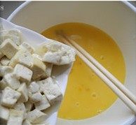 蛋包豆腐丁 ,蛋液中加入处理好的豆腐，充分拌匀，豆腐用鸡蛋包裹均匀。
