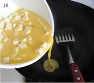 蛋包豆腐丁 ,锅中放油烧热，倒入豆腐鸡蛋液翻炒，加少许料酒可除去蛋腥味。