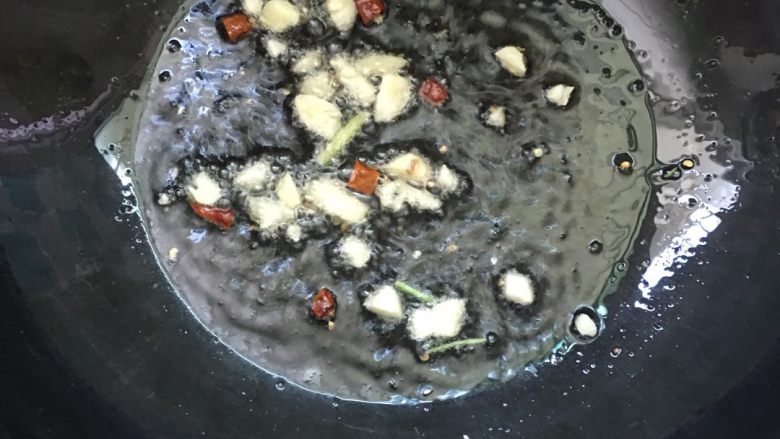 #年夜饭#猪蹄芋头煲,把锅内的油倒出装在无水的盆里。锅中留少许底油，放入蒜瓣爆香。