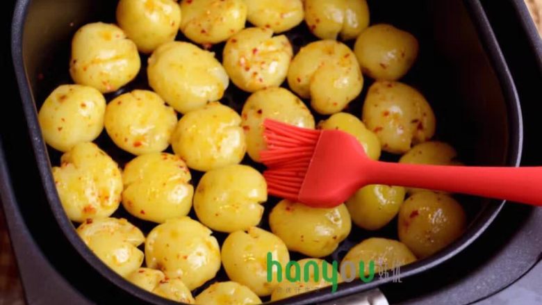 韩优空气炸锅---烤土豆,把搅匀的调料均匀的刷在小土豆上。