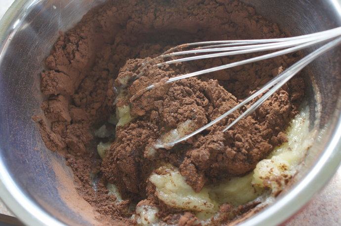 无蛋无油的低卡巧克力布朗尼 ,把青果沙司，细砂糖和可可粉放入大碗里，搅拌均匀至糖溶化。加入香草精，苏打粉和盐，搅拌均匀。