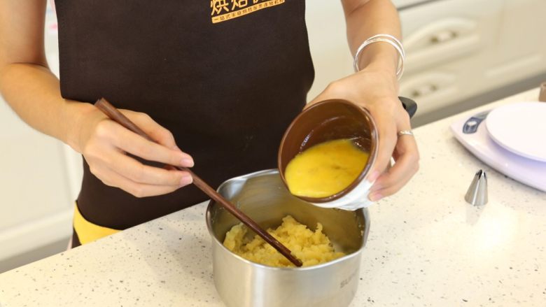 卡士达泡芙,4.等黄油面糊冷却到不烫手的状态，大约60度左右，分多次小量加入鸡蛋液。每次加入鸡蛋液都要面糊与鸡蛋完全混合才再加入鸡蛋液。