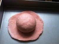 粉嫩帽子面包,较大面团滚圆放置在圆片中间。