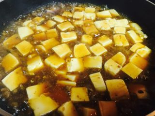 香辣豆腐,再倒入豆腐，动作要轻.煮一分钟左右，用淀粉水勾芡即可.再洒上蒜苗碎或葱花都可以.