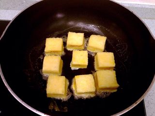 花生酱夹心西多士,裹上蛋液的吐司块逐块放入锅中，全程小火慢煎。