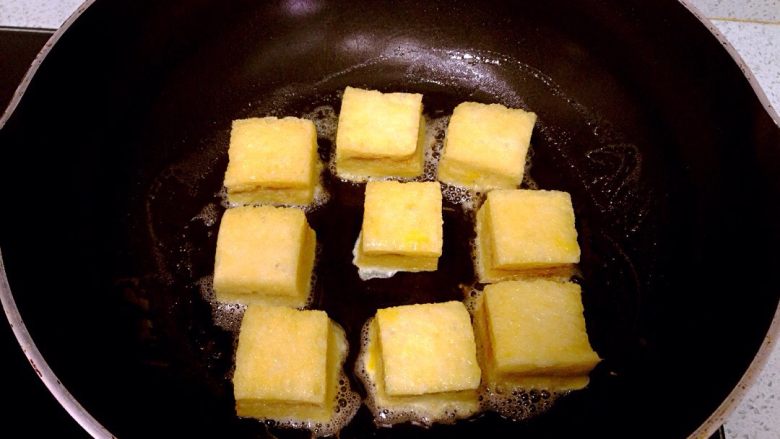 花生酱夹心西多士,裹上蛋液的吐司块逐块放入锅中，全程小火慢煎。