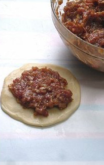 最接地气的鲜肉月饼,将坯子按扁，擀成中间厚边缘薄的月饼皮，上面放上一勺馅料，包起，捏紧实口。