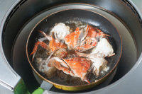 不可错过的酱香梭子蟹 ,蟹横切面封口后，让蟹平方在油面上，让整只蟹都变色后捞出控油备用。