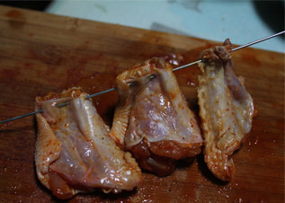 鸡翅的另类吃法——鱼籽鸡翅,鸡翅提前一天用奥尔良腌料腌制，去掉鸡骨头，然后一头用铁钎封住口，穿好。