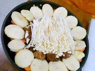 一锅出十菜,胡萝卜上摆放土豆后撒少许盐和蘑菇粉。