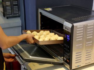 蜂蜜椰蓉小面包,11.在容器上抹上色拉油，将蘸满底料的面包胚放入容器中。二次发酵后就，放入预热好180度的烤箱中层烤25~30分钟。