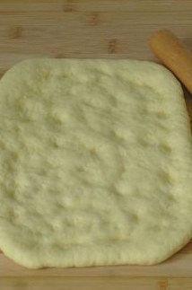 南瓜子油佛卡夏,醒好的面团擀成长方形薄片，然后用指腹在上面轻按些小坑，便于调味油聚集。