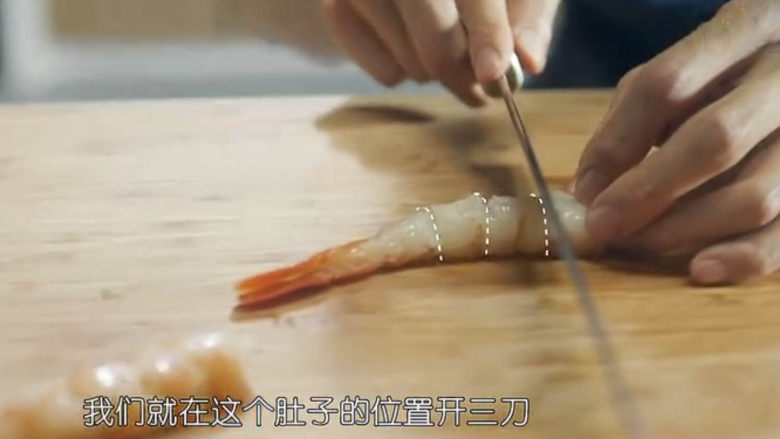 虾骨柔情天妇罗,剔除虾线，用小刀在虾身两侧各划上3刀，这样可以防止油炸过程中虾身蜷缩。