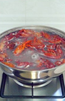 火爆流行街头的龙虾盖浇饭 ,水开后放入处理好的小龙虾，待虾全部变色，水再次沸腾即可关火。