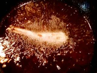 虾骨柔情天妇罗,锅里放油烧热至开始有点冒烟，转中小火放入虾炸至两面结痂捞出。