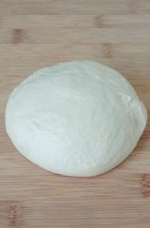 【胡萝卜咸面包】,将发酵好的面团取出，擀薄卷起两次，擀去面团内的大气泡。