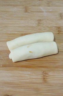 【低粉花生酱面包卷】,将面片两头对着卷起，要对称着都卷到中间位置。