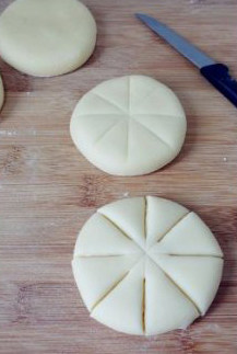 低粉做的面包很绵软：椰蓉面包 ,先用刀给椰蓉包打上4道对称的划痕，然后再用小刀将3/2处割开成花瓣样。
