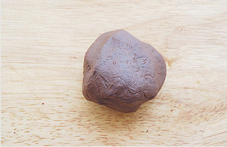 爆表的颜值与味值【巧克力酥皮泡芙】 ,将湿润的砂砾状材料在案板上搓，边搓边折叠，最后全部黏在一起成为一个团；