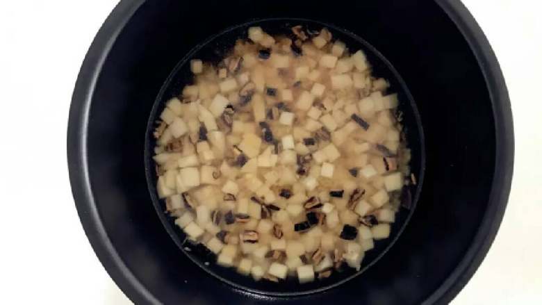 宝宝辅食：芋头香菇炊饭,把步骤5中炒好的大米混合物放入电饭锅，倒入300g水（大米：水=1：3），并且翻拌均匀，按下电饭锅煮饭模式就可以了。
》如果要加入浸泡香菇的水，需对应减少加入的清水。