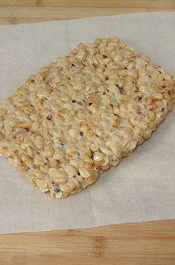 徐州，古老的麦芽花生糖 ,菜板上铺油纸（防粘），倒出花生糖，按压到自己喜欢的厚度。