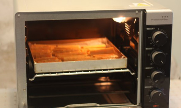 【桂花蜂蜜红薯条】,烤箱上下火200度预热好，把红薯条放入烤箱中层，烘烤15分钟