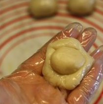 【蛋黄酥】,把小面团从中间按扁，擀成圆形，把小面团包入豆沙红豆沙馅，收口收紧