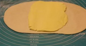 【法式酥皮】,把黄油放在面团中间，如果黄油的形状不合适要稍作整理。