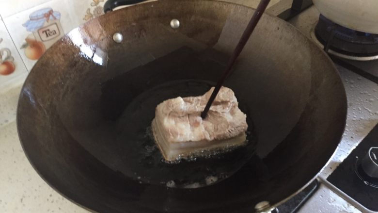 四川烧白（也叫梅菜扣肉）,五花肉放油锅内炸，只炸猪皮那一面