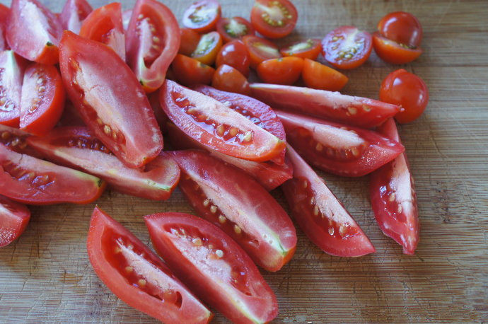 手工的有机美味封存——《日晒番茄 & 橄榄油浸日晒番茄》,用锋利的刀将番茄切半（小番茄就切半，大番茄，可以切成4等分。