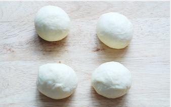 【杏仁豆沙面包】,取出面团轻轻按压排气，分成每个45g左右的面团，滚圆盖保鲜膜松弛15分钟；