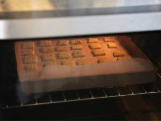 葱香苏打小饼,9.放在铺了油纸的烤盘上，放入预热好180度的烤箱中层烘烤10分钟左右，至饼干表面金黄即可
