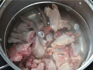 姜汁芋儿鸡,将斩好的公鸡放入冷水锅中，焯一遍水，去除一定的腥味。