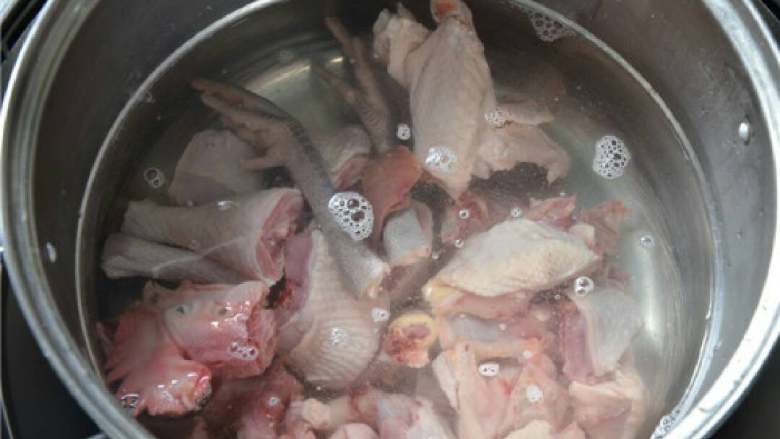 姜汁芋儿鸡,将斩好的公鸡放入冷水锅中，焯一遍水，去除一定的腥味。