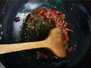 干煸肥肠,锅里留底油，放入干辣椒、干花椒、姜片、蒜片，炝出香味。