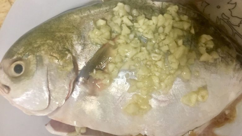 柠檬酱蒸白鲳,把蒜茸塞满内腔和铺在鱼的表面