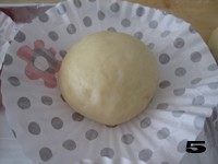 柔软可爱小面包——【肉松海苔小狮子面包】,取出面包或蛋糕纸铺平，将面团放入中央进行二次发酵。