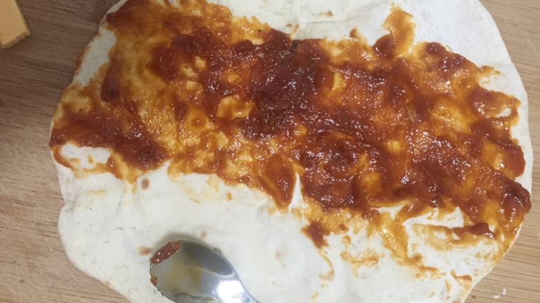 安其拉达（Enchiladas chicken）墨西哥菜,拿一张墨西哥薄饼，饼中间抹上安其拉达酱汁，抹匀
