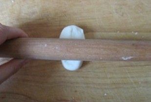 层层酥脆的极致诱惑---栗香梅花酥 ,饧好的油酥球用擀面杖擀成长条状