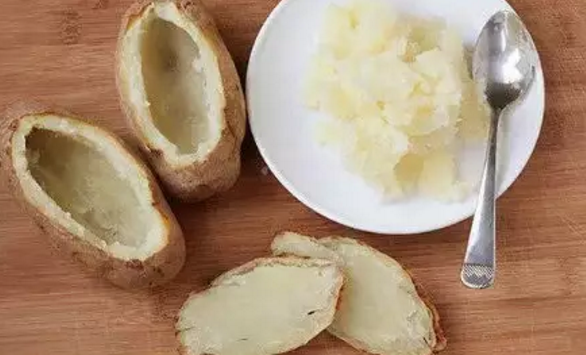 奶酪烤土豆,用烤箱手套拿土豆，把土豆的顶部切下，形成一个类似独木舟的形状。小心地把大部分土豆挖进一个碗里。留下约0.5cm厚的土豆在皮上。