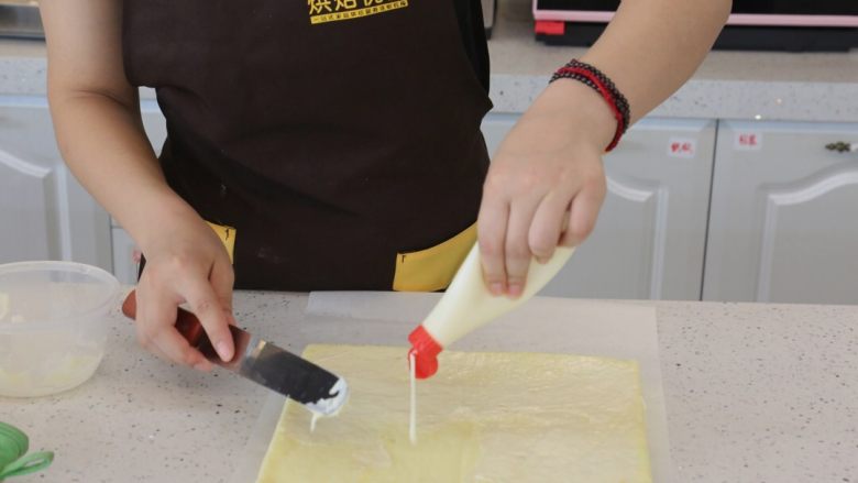 肉松沙拉卷,15.将烤好的蛋糕卷反扣脱模，在蛋糕卷反面涂上沙拉酱，抹均匀。
