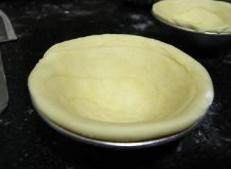 葡式蛋挞,用大拇指由中心位置按扁，边按边往外推，直到挞皮高出膜子一点点就可以了。
