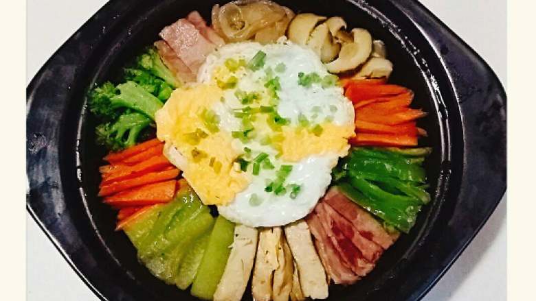 韩国石锅拌饭+#挑战鸡蛋的100种做法#,把石锅移出，揭开锅盖，蛋上面撒上葱花，一锅色彩鲜艳又美味的石锅拌饭做好了。