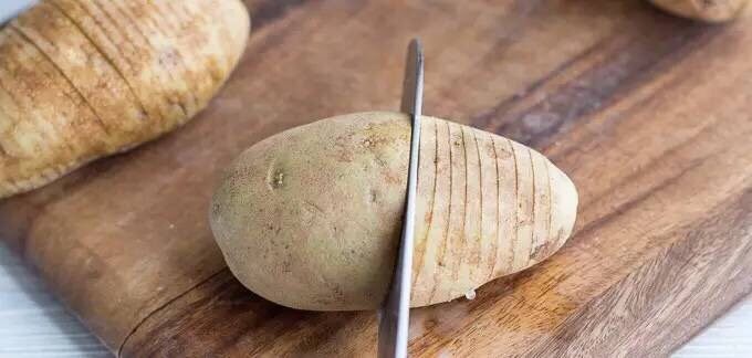 烤土豆,用刀在土豆上切片，但是要注意不要切断。