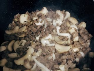 茄汁蘑菇肉酱意面,把腌制好的牛肉加入剩余切片的口蘑炒至变色盛出备用