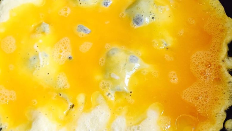 鸡蛋炒年糕#挑战鸡蛋的100种做法#,平底锅加热倒入油把鸡蛋液倒进锅里