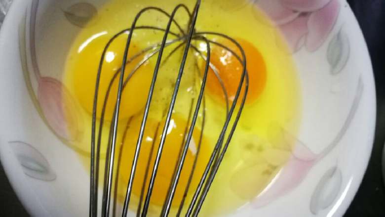 金银恋#挑战鸡蛋的100种做法#,用蛋抽把鸡蛋打散。