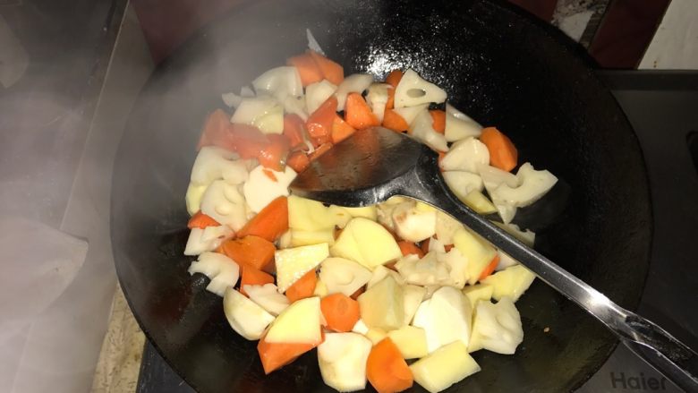砂锅牛肉乱炖,胡萝卜，莲藕，土豆放入锅中煸炒片刻。