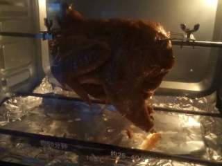烤全鸡,腌制冷藏后的鸡，穿在烤架上，鸡肚子用牙签缝上固定好。烤箱230度预热,用旋转烧烤功能烤30分钟。