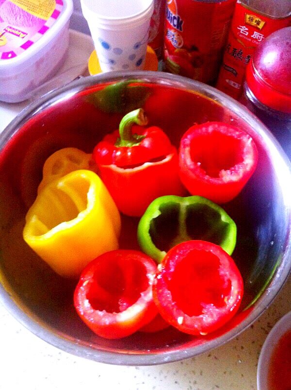 （少儿菜谱）蔬菜焗饭,把彩椒、番茄的头切开，掏空。彩椒的囊仍掉，番茄的囊保留待用。